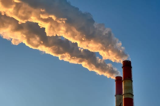 white smoke is coming out of the pipes in the blue sky. High quality photo