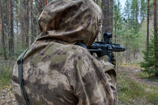 a man in the forest shoots from a machine gun. High quality photo