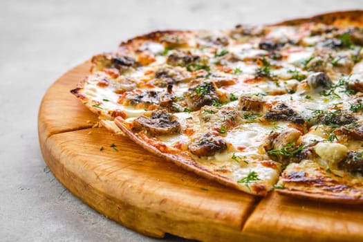 Thin-crust pizza dough with mushrooms and lot of melted cheese (closeup photo with shallow depth of field)