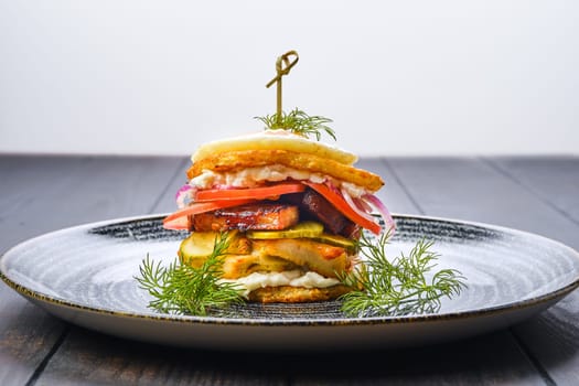 Potato fritter burger with chicken breast, bacon, pickled cucumber and fresh tomato