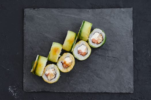 Rolls with eel, cucumber and tuna on slate plate