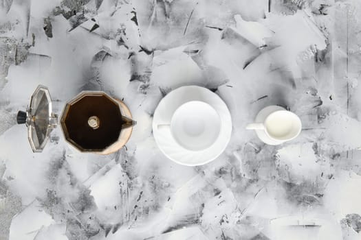 Top view of geyzsr coffee maker, cup and pot with milk on abctract background