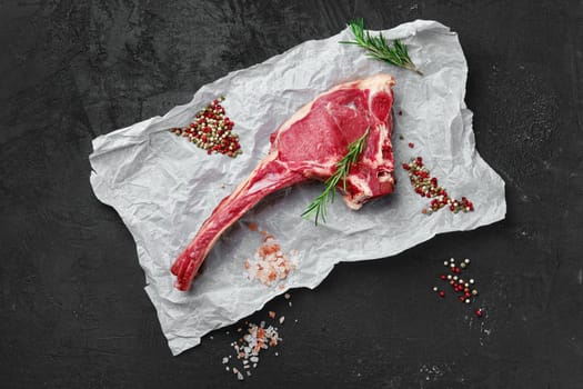Top view of raw prime ribeye steak on wooden wrapping paper