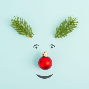 Face of a reindeer with a red bauble nose, fir antlers and friendly eyes, merry christmas greeting card