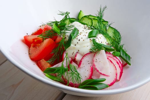 Salad with radish, tomato, cucumber, onion and sour cream