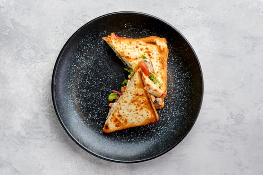 Top view of sandwich with chicken, tomato and cheese cut on triangle pieces