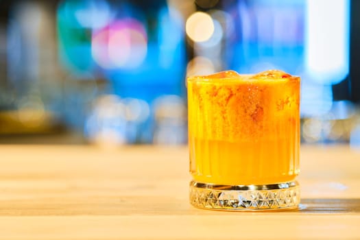 Cold cocktail with tequila and sea buckthorn (soft focus photo with shallow depth of field)
