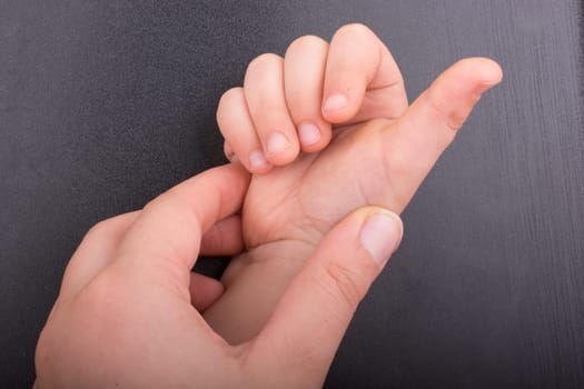 Toddler hand with dark color background