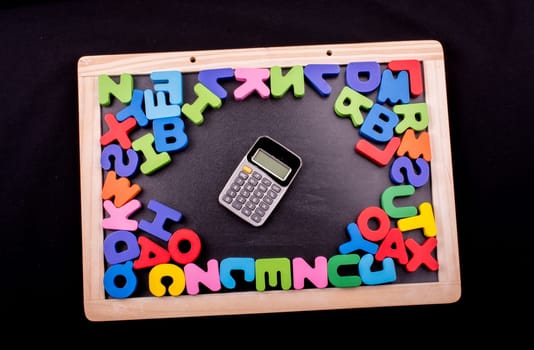 Calculator and Colorful Letters of Alphabet made of wood