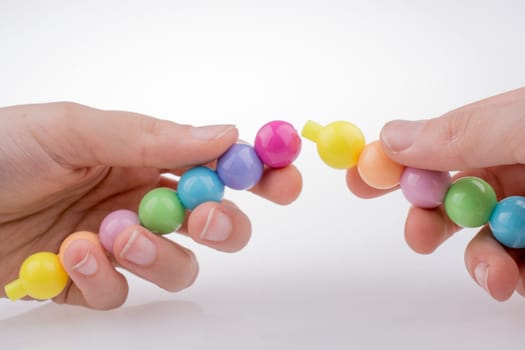 Hand holding Color beads with facial expression on white background