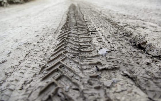 Detail of off-road car marks on a wet and muddy ground