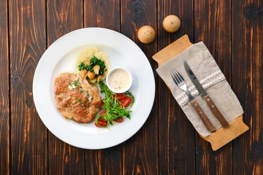 Plate with fried pork meat, mashed potato, mushrooms and tomato