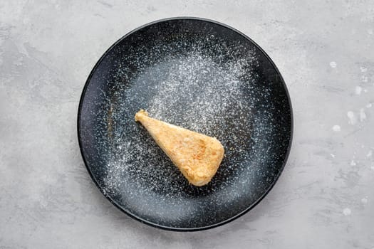 Top view of triangular piece of classic Napoleon cake on a plate