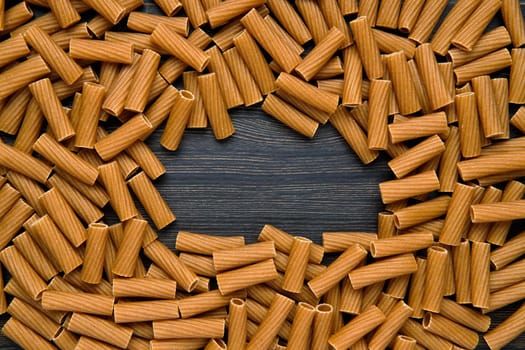 Top view of tortiglioni pasta with copy space place. Grooved helical tube pasta.