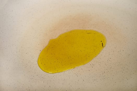 Olive oil on the surface of a frying pan, closeup view