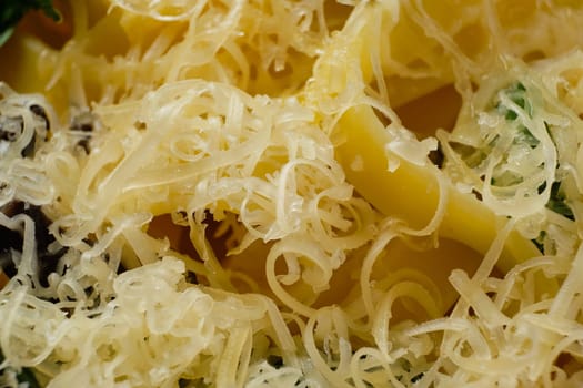 Macro photo with shallow depth of field of pasta with parmesan, chopped olives and basil