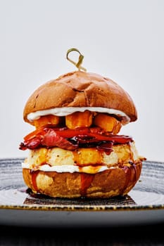 Close up view of burger with beef, bacon, pumpkin and tomato