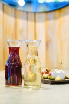 Two decanters with wine and plate with snack on background (soft focus photo with shallow depth of field)