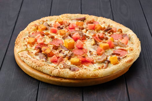 Pizza with pumpkin, sausage, bacon and honey mushrooms on wooden table