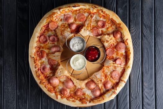 Top view of pizza with sausage and three sauces