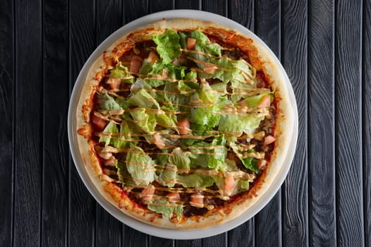 Pizza with ham, mustard sauce and salad leaves