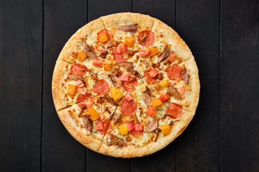 Top view of pizza with pumpkin, sausage, bacon and honey mushrooms on wooden table