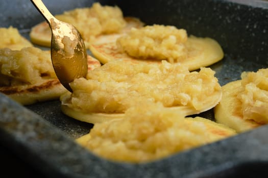 Closeup view of pancakes with caramelized apple and coconut cream (photo with shallow depth of field)