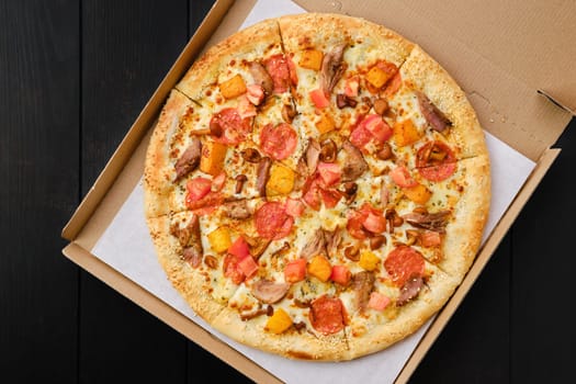 Pizza with pumpkin, sausage, bacon and honey mushrooms in take away package