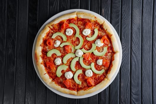 Pizza with salmon, avocado and feta cheese