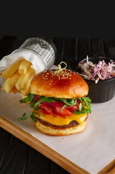 Juicy beef burger with lingonberry sauce, melted cheese, arugula served with fried potato and red cabbage