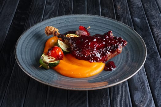Fried duck thigh with carrot puree and zuccini, pepper and onion on wooden skewer