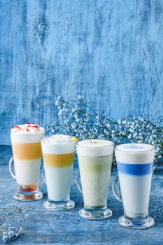 Variations of matcha green tea and chai on blue shabby background