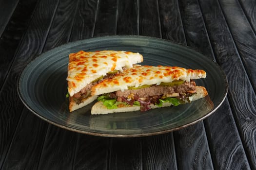 Club sandwich with meat, pickled cucumber , salad and melted cheese