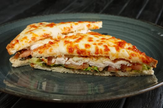 Club sandwich with chicken fillet, pickled cucumber , salad and melted cheese