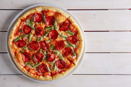 Pizza with green beans, salami and mozzarella. Top view.