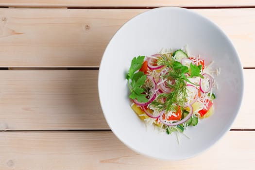 Salad with fresh bell pepper, cucumber, red onion, boiled potato and cheese. Top view.