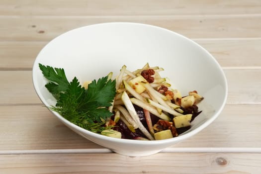 Salad with beetroot, pear and walnut on wooden table