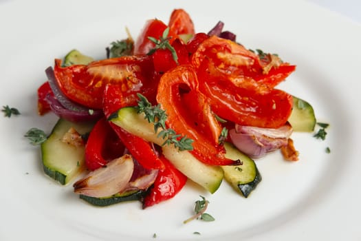 Grilled vegetables on white plate cutted on slices. Close up photo with selective focus.