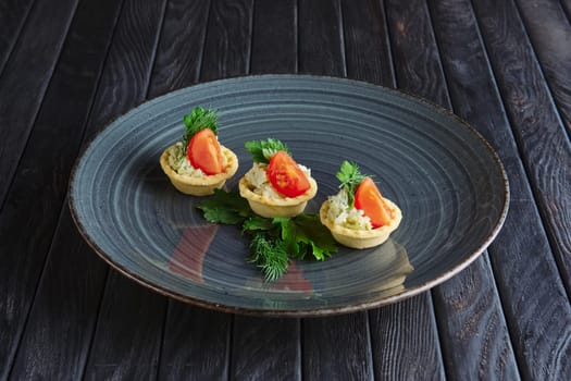Appetizer for reception. Tartlet with mashed potato, soft cheese and pickled cucumber