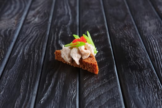 Appetizer for reception.Piece of brown bread with fish pate and green onion
