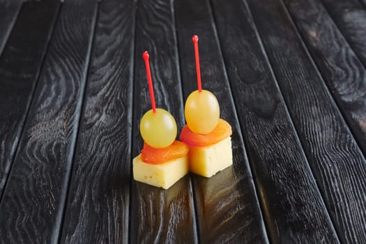 Appetizer for reception.  Cheese, dried apricot and grape on skewer
