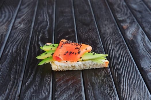 Appetizer for reception. Sandwich with smoked salmon, ricotta snd avocado