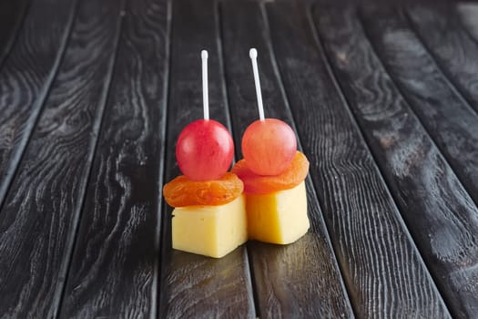 Appetizer for reception.  Cheese, dried apricot and grape on skewer