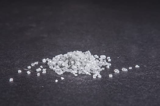Sea salt on dark background. Side low point of view.