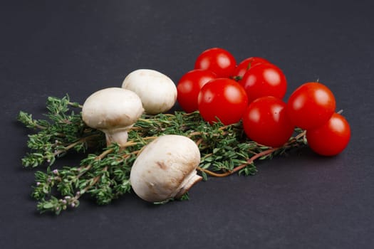 Fresh ingredients: tomato cherry, champignon, thyme on gray background