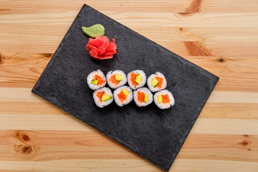 Rolls with salmon and avocado on slate plate