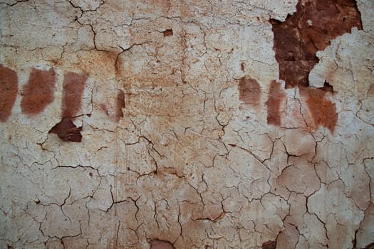 The texture of a brown concrete wall with cracks and scratches can be used as a background