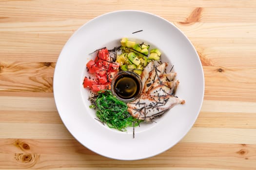 Unagi sashimi rice bowl with avocado, seawed, tomato and soy sauce