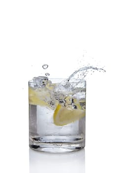 Ice cube and lemon splashing cocktail in oldfashioned glass. Drink with splashing citrus isolated on white.