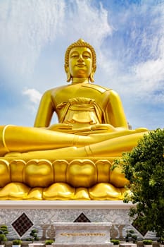 "Phra Buddha Dhammakaya Thep Mongkol"" is a Big golden buddha statue made of copper, as tall as a 20-storey building (69 meters), located at Wat Paknam Bhasicharoen. Bangkok, Thailand on a sunny day"